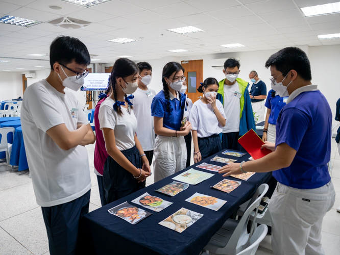Participants sort out images of dishes in a vegan food guessing game. 【Photo by Daniel Lazar】