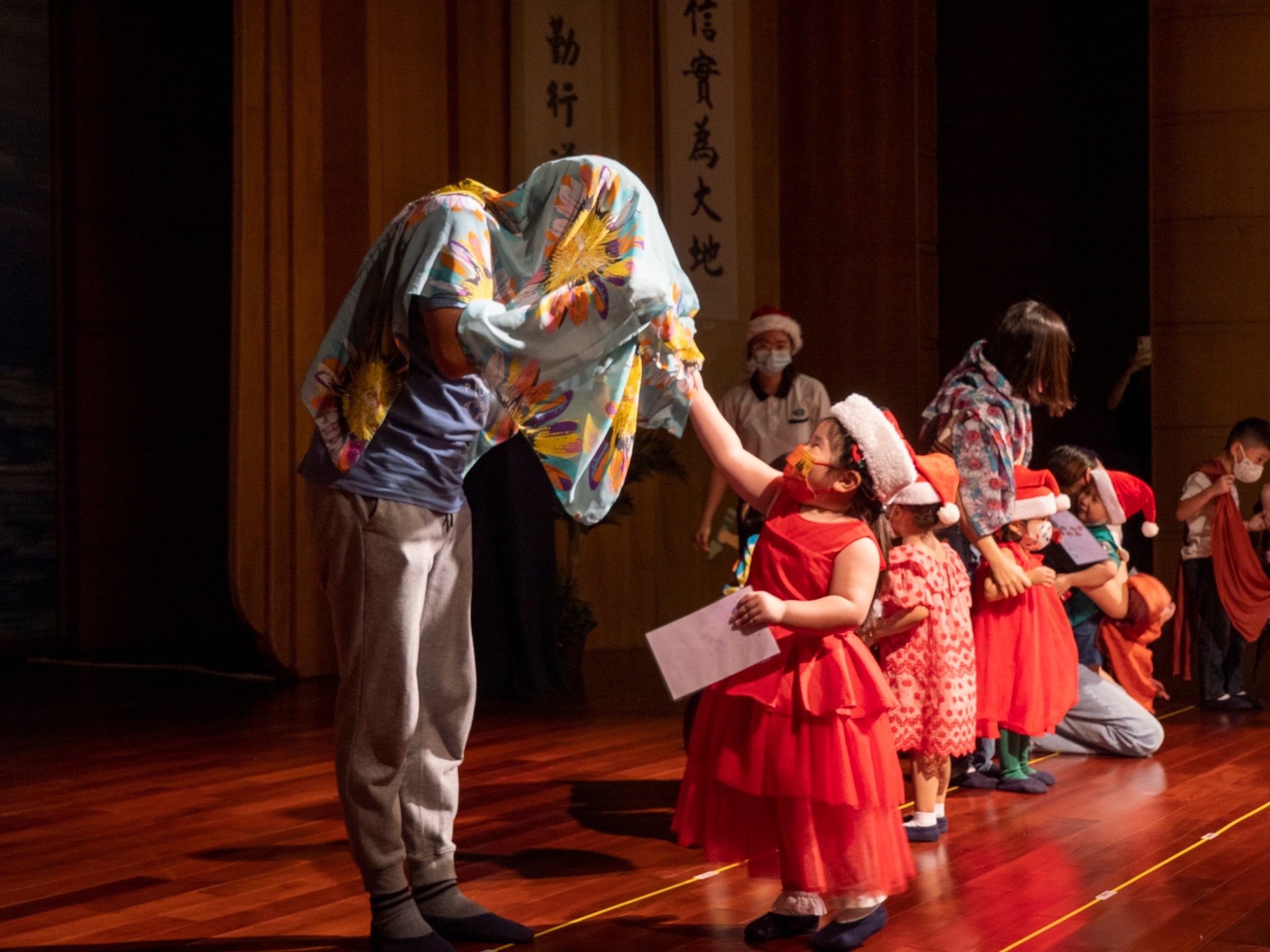 Covered with shawl, parents are identified by their children in a gift-giving game.【Photo by Harold Alzaga】