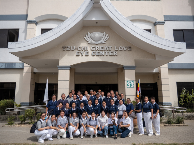 Volunteers pose for a group photo at the facade of the Tzu Chi Great Love Eye Center. 【Photo by Harold Alzaga】
