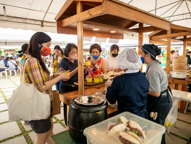 Guest buy vegetarian cuapao and fried oyster mushroom from a Tzu Chi food stall. 【Photo by Daniel Lazar】