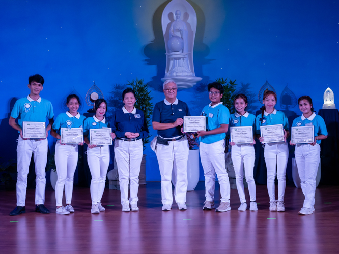 Tzu Chi Philippines CEO Henry Yuñez (center) and Education Committee volunteer Rosa (4th from the left) award certificates of recognition to honor graduates (from left to right): John Arnel Gonzaga (cum laude), Devine De Guzman (cum laude), Reca Mae Atillo (cum laude), Joshua Daarol (magna cum laude), Mary Joy Alvarez (cum laude), Geramie Rufil (cum laude), Anne Kimberly Salonga (cum laude). 【Photo by Matt Serrano】