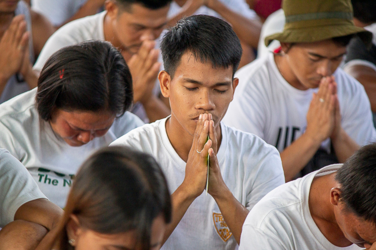 Jonathan Demakiling participates earnestly in a prayer led by Tzu Chi volunteers. 【Photo by Matt Serrano】