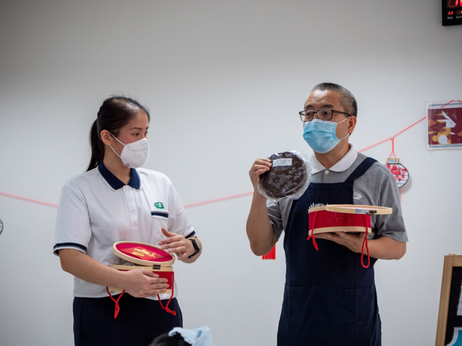 Tzu Chi volunteer Liu Yue Sen (right) shows a sample of Tikoy to Preschool students. 【Photo by Daniel Lazar】