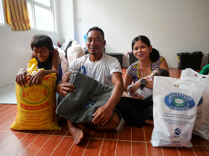 Marlon Cahusay brings relief items to his family in the evacuation center, grateful for Tzu Chi's assistance that will soon help him rebuild his home. 【Photo by Matt Serrano】