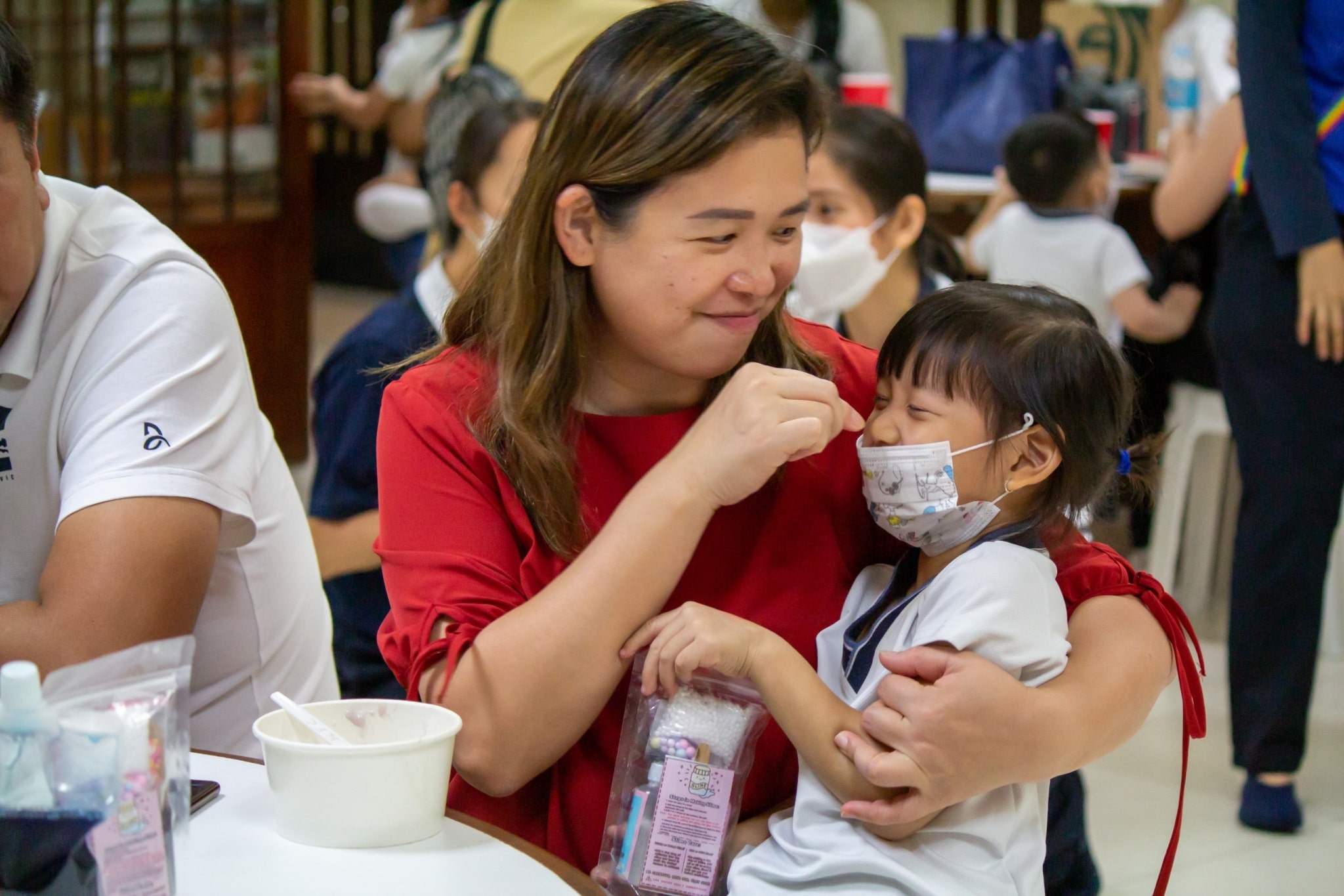 Mother and daughter shares a light moment at the kiddie market of Tzu Chi Great Love Preschool Philippines.【Photo by Marella Saldonido】