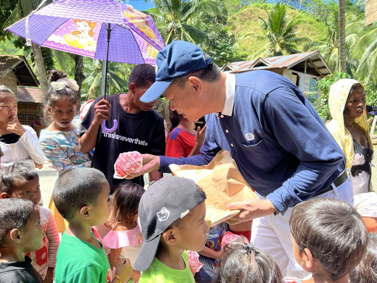 Tzu Chi Davao officer-in-charge Nelson Chua distributes vegetarian buns to farmers’ children.