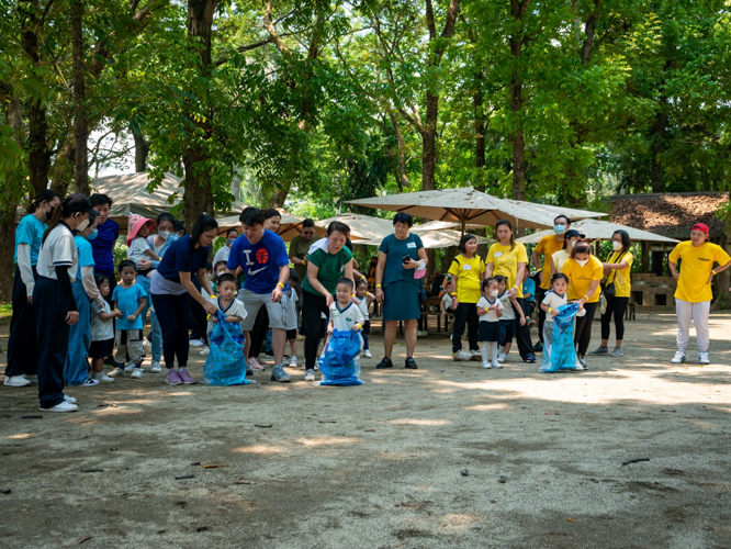 With guidance from parents, students compete in the classic sack race. 【Photo by Daniel Lazar】