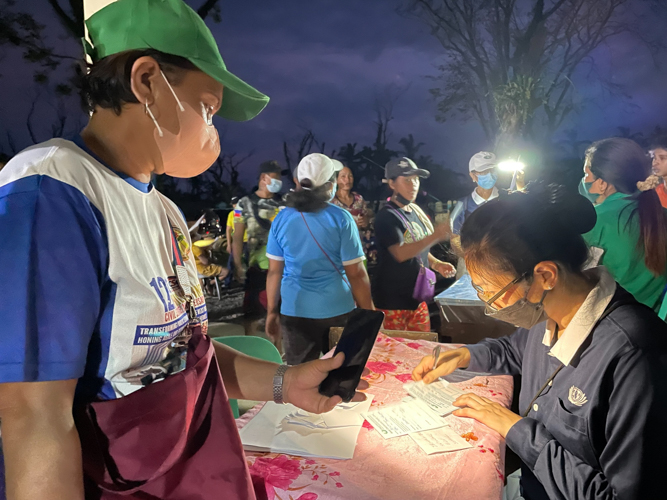 Volunteers use generators, emergency lights, and cellphones when stub distribution lasted until night. 【Photo by Jeaneal Dando】