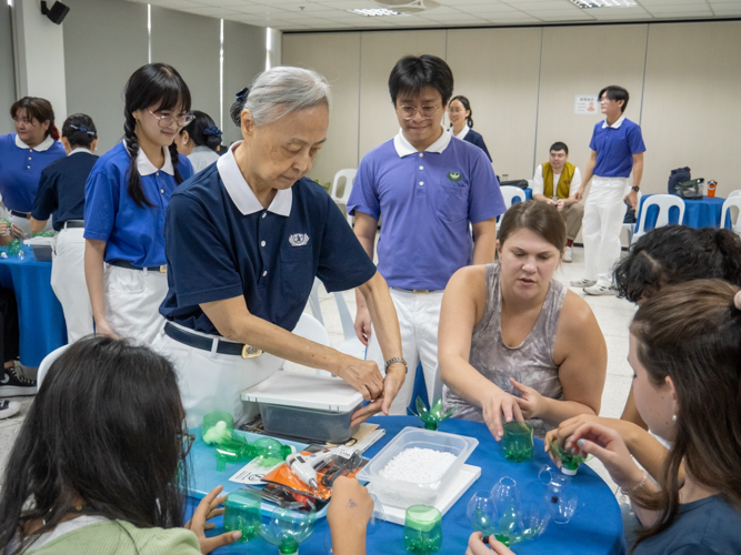 A Tzu Chi volunteer helps ISM students during the upcycling activity. 