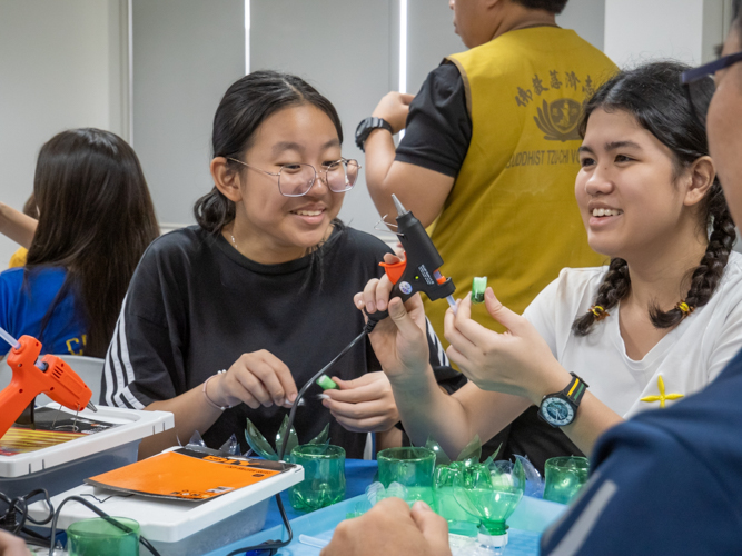 Students happily engage in a hands-on upcycling activity, making lotus flowers out of PET bottles. 