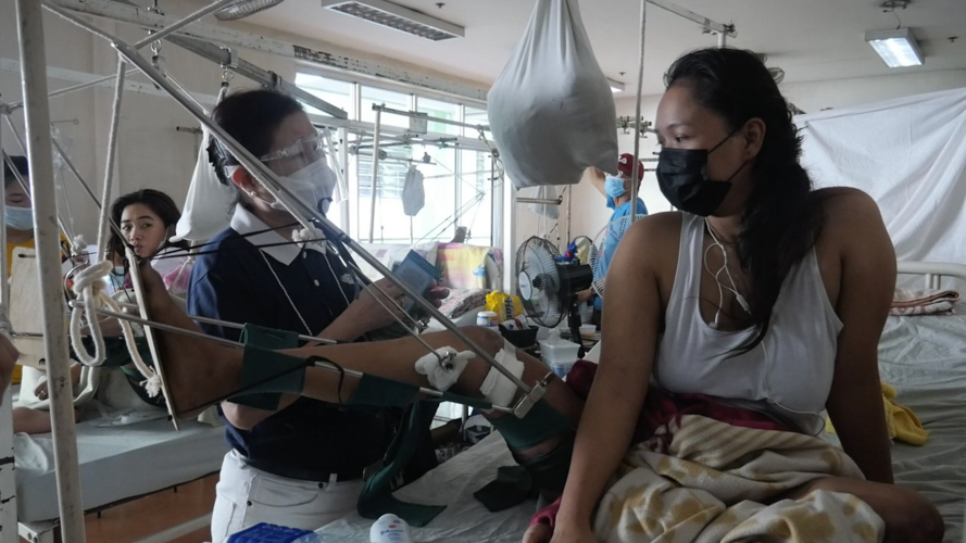 Tzu Chi volunteer Edita Young (left) visits Micholle Manila at the Philippine Orthopedic Center. 