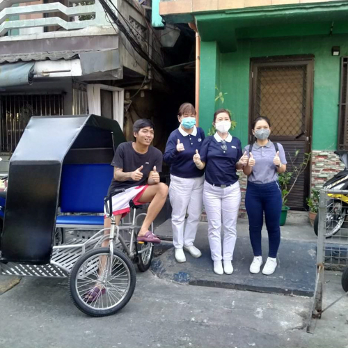 Micholle Manila’s husband Carlo Francisco (first from left) poses with Tzu Cho volunteers and the pedicab he received from them for his livelihood. 
