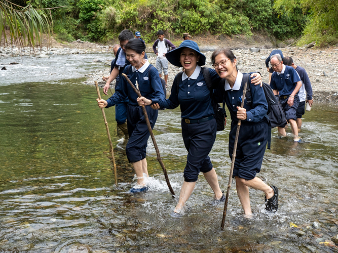 Tzu Chi volunteers enjoy their stroll while crossing the river on their way to the banana planting site. 【Photo by Matt Serrano】